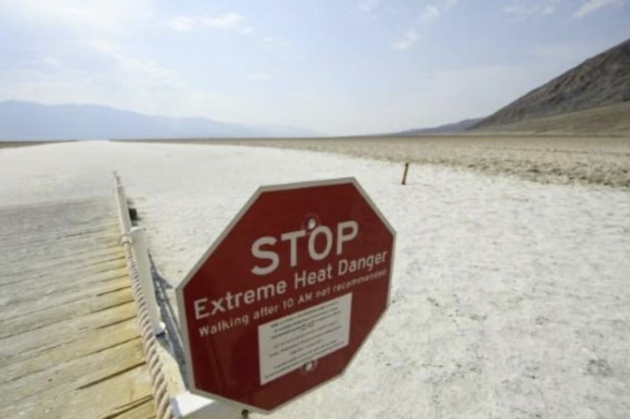Un cartel advierte del riesgo de calor extremo en las salinas de Badwater Basin, en el parque del valle de la Muerte (California)