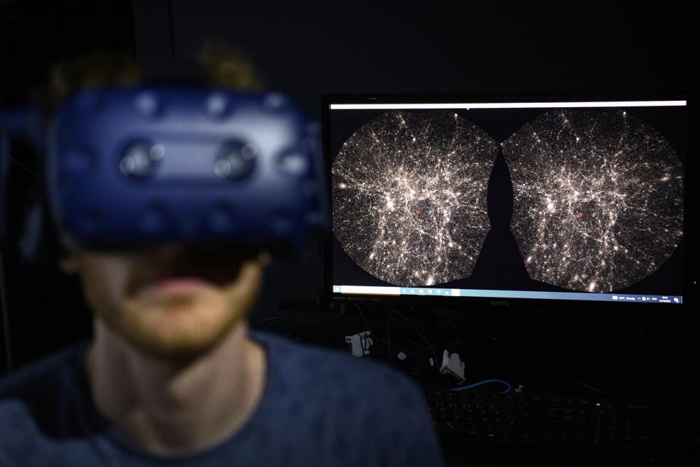 Hadrien Gurnel, ingeniero de software del Laboratorio EPFL de Museología Experimental (eM+) explora con un casco de realidad virtual un mapa en tres dimensiones dand play