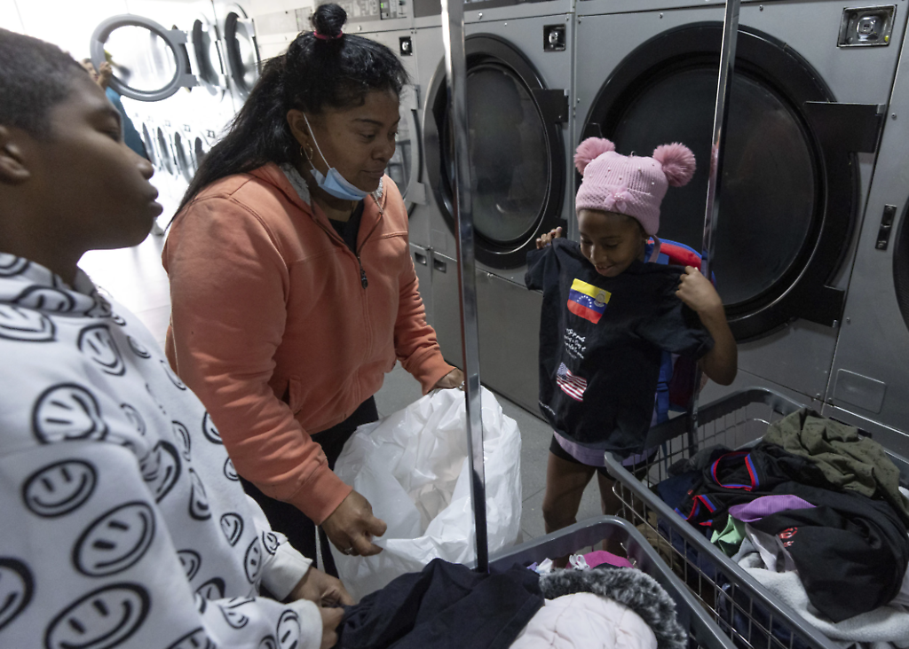 Sosteniendo una camiseta con las banderas de Venezuela y Estados Unidos, y el mensaje en español: “Sí se pudo, gracias a Dios. La espera valió la pena. ¡Lo logré! en la lavandería cerca del refugio para migrantes donde se alojan en Tijuana, México, el viernes 31 de enero de 2025.