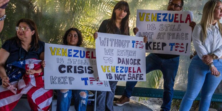 Venezolanos sostienen carteles que describen la situación actual de Venezuela durante una vigilia realizada en Doral